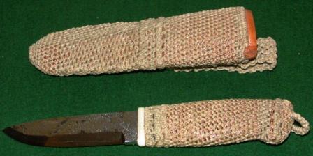 Knife with handforged steel-blade carrying initials J.A. Handle and leather sheath coated with rope and copper-thread.