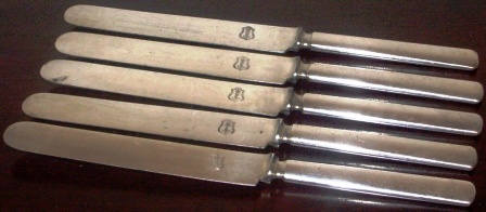 Early 20th century table knives, marked with crown and anchor. 