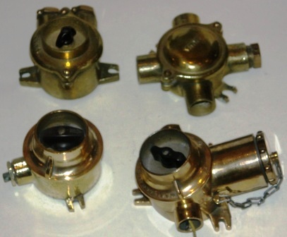 A variety of 20th century switches and junction boxes made of brass.