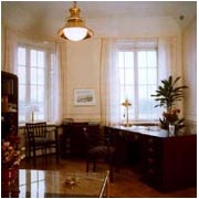 Shipping company office furnished with restored 20th Century original ship's desk, chest of drawers, chairs, bookcase and newly made brass lamps.