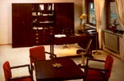 Part of an office interior furnished with restored 20th century original ship's desk, bookcase, chest of drawers, cupboard, wardrobe, swivel-chair, table armchairs and newly made brass lamps.