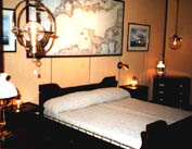 Exhibited bedroom furnished with restored 20th century original ship's king-size bed, chest of drawers, bedside tables, original nautical chart and paintings as well as newly made brass lamps.