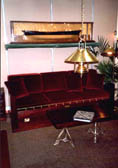 Exhibited part of a living room, furnished with restored 20th century ship's bunk bed sofa, coffee table, sideboard and newly made brass lamps.