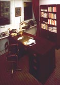 Part of an office interior furnished with restored 20th century ship's desk , swivel armchair, book case and newly made desk lamp.