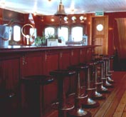 Part of a seafood bar onboard a restaurant ship, furnished with restored 20th century ship's bar-stools and original nautical fixtures.