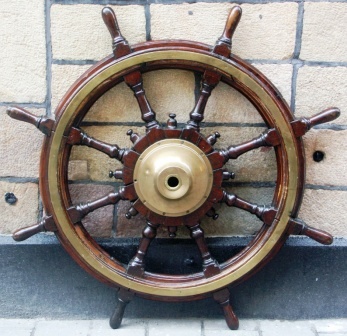 Late 19th century eight-spoked mahogany ships wheel with double brass bands and central brass hub.