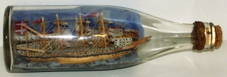 Early 20th century sailor-made ship model housed in bottle depicting a Danish 4-masted barque.