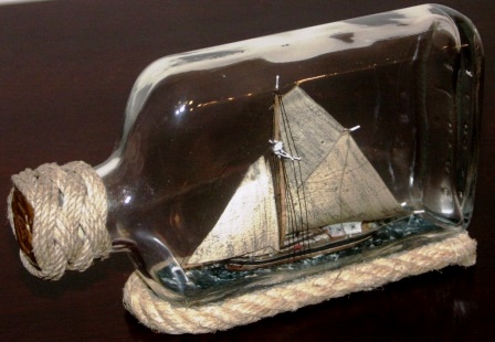 20th century ship model housed in bottle depicting "Vedjakten ELVIRA 1857", a traditional Swedish archipelago sloop carrying wood. Signed GF (Göran Fors).