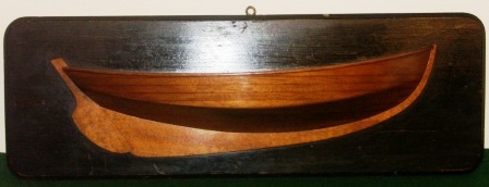 Early 20th century half-hull made of solid mahogany, mounted on wooden panel.