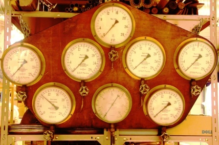 20th century pressure gauges in brass mounted on wooden panel