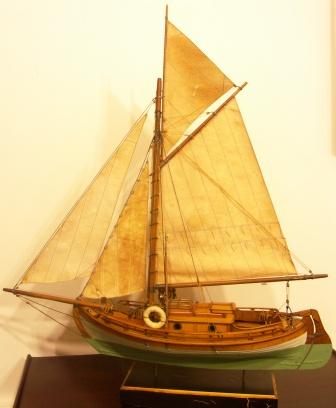 Gaff-sail rigged cabin boat with set sails. 20th century model.