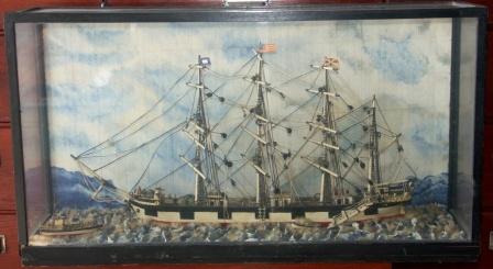 Early 20th century sailor-made model depicting a four-masted barque, cable ship and rowing boat. Mounted in glass case.