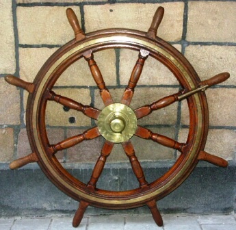 Late 19th century eight-spoked ships wheel. Made of mahogany. With double brass bands and central brass hub.